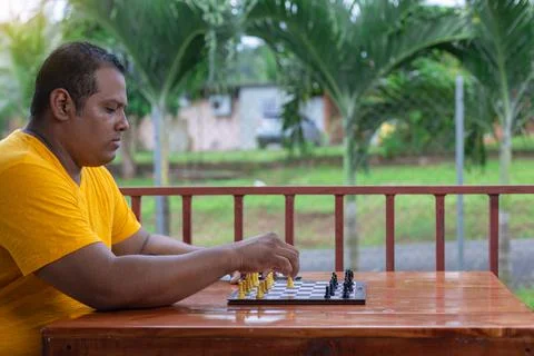Hispanic man playing chess at the table Stock Photos