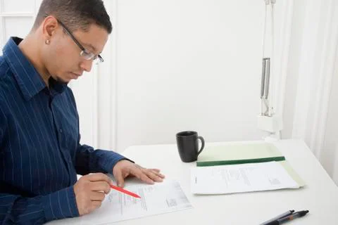 Hispanic man reading paperwork Stock Photos
