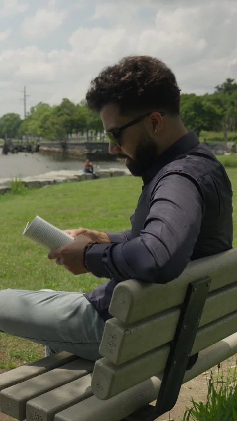 Hispanic Man Reads at Park Bench in side Vertical Video Stock Footage 246387203