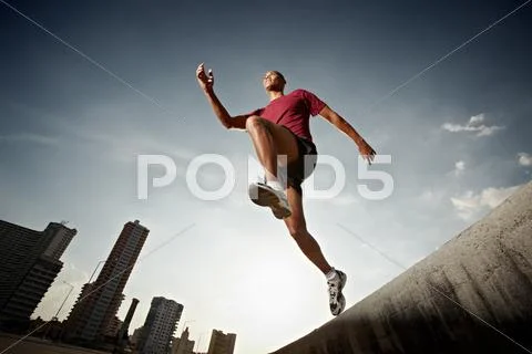 Hispanic man running and jumping from a wall Stock Photos