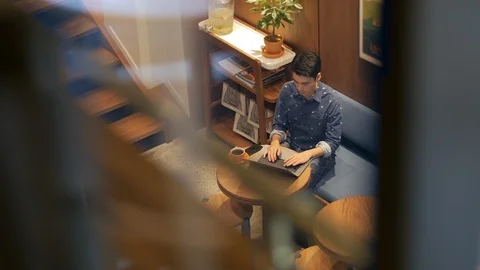 Hispanic man sitting in coffee shop with laptop and cellphone drinking coffee Stock-Footage 101659328