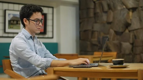 Hispanic man sitting in coffee shop typing on a laptop Vídeo Stock 101715423