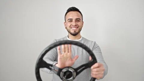 Hispanic man smiling confident using steering wheel as a driver over isolat.. Video stock 246142896