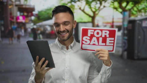 Hispanic man smiling with tablet and for sale sign standing outdoors in bus.. Stock Footage 315565848