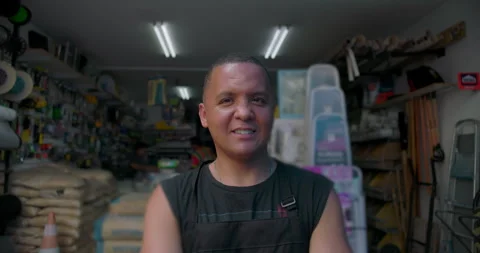 Hispanic man standing inside hardware store looking slightly aside, calm confide Video stock 327385558