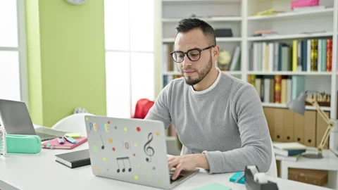 Hispanic man student using laptop wearing glasses at library university Stock Footage 246143103