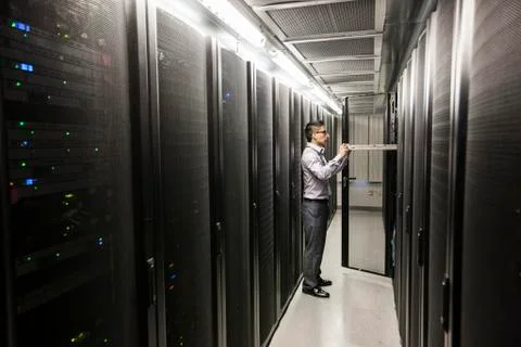 Hispanic man technician doing diagnostic tests on computer servers in a large Stock Photos