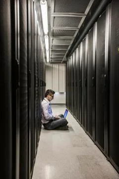 Hispanic man technician doing diagnostic tests on computer servers in a large Stock Photos