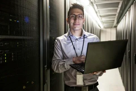 Hispanic man technician doing diagnostic tests on computer servers in a large Stock Photos