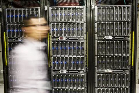Hispanic man technician doing diagnostic tests on computer servers in a large Stock Photos