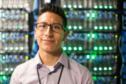 Hispanic man technician in a large computer server farm. Stock Photos