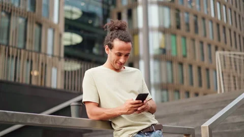Hispanic man texting on cell phone while waiting for somebody Stock Footage 158070585