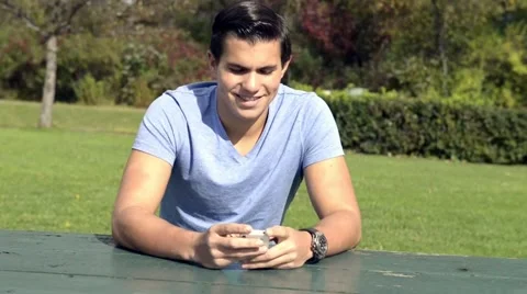 Hispanic man texting in park Stock Footage 42675652