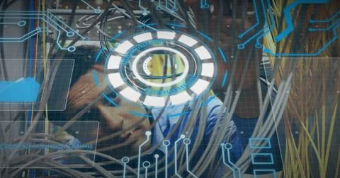 Hispanic man threading network cables in server room, with patch panels and Stock Photos