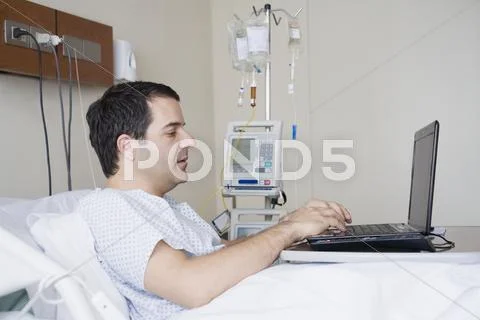 Hispanic Man Using Laptop In Hospital