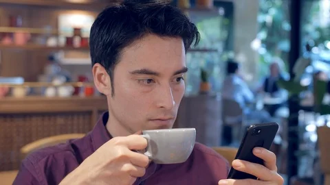 Hispanic man using smartphone and drinking coffee Vídeo Stock 101707720