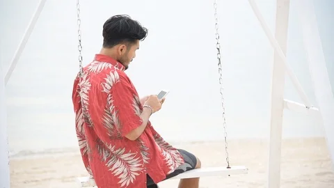 Hispanic man using smartphone on the beach outdoor with the sunlight. Attractive Stock Footage 124302333