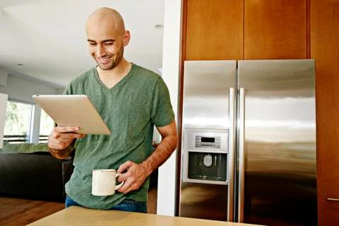 Hispanic man using tablet computer in kitchen Stock Photos