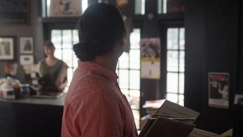 Hispanic man in a vinyl record store sturns and smiles at the camera Video stock 122591948