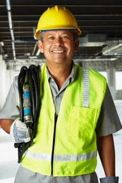 Hispanic man wearing hard hat and reflective vest Stock Photos