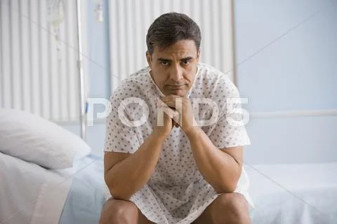 Hispanic man wearing hospital gown Stock Photos