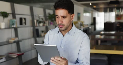 Hispanic man working on tablet standing in coworking office Stock Footage 315549513