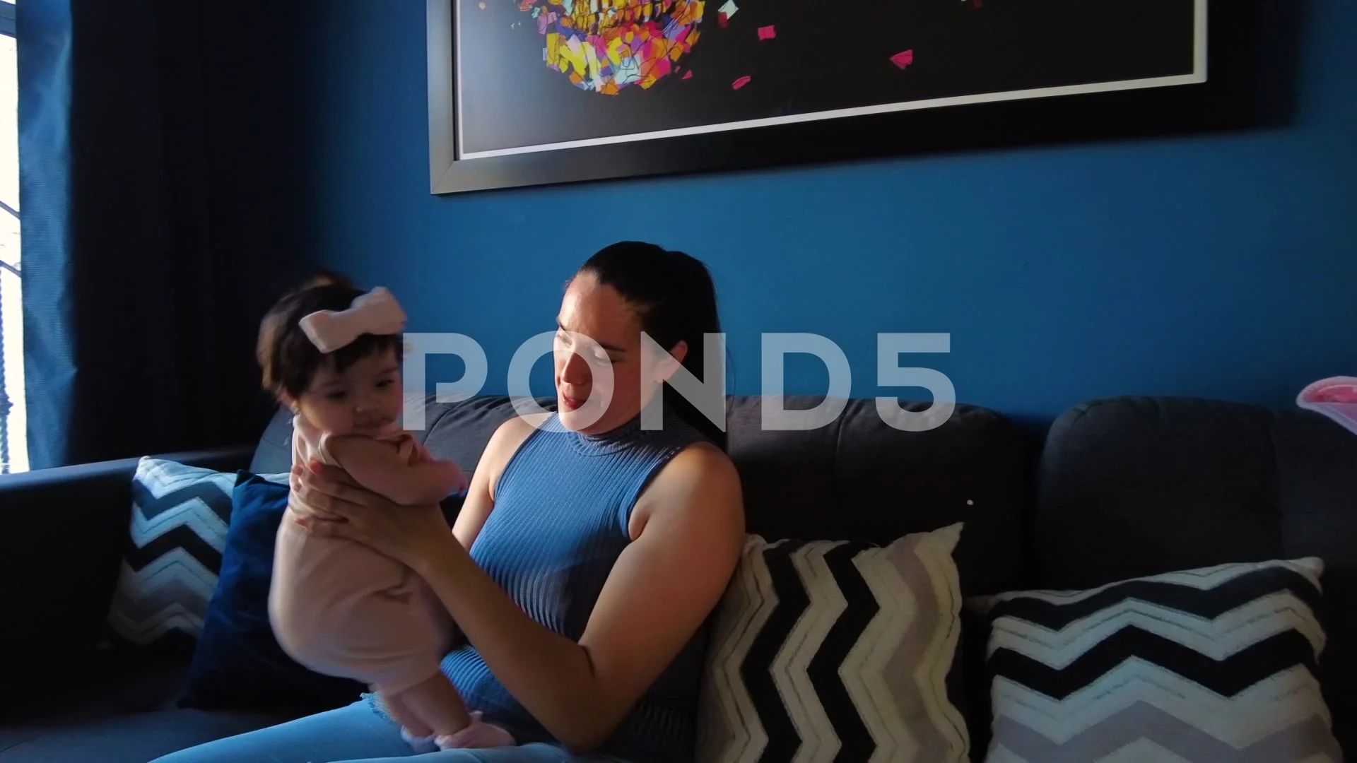 Hispanic mom happily playing with her 3 month old baby girl in the living  room, image size:1920x1080