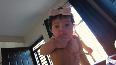 Hispanic mom happily playing with her 3 month old baby girl in the living room Video stock 239468871