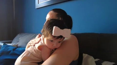Hispanic mom hugging her 3 month old baby girl in the living room Video stock 239466531