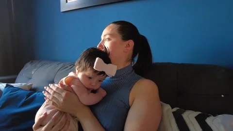 Hispanic mom hugging her 3 month old baby girl in the living room Video stock 239467564