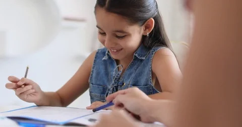 Hispanic Mother Helping Girl Doing School Homework At Home Stock Footage