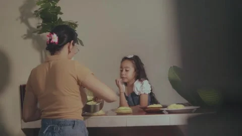 Hispanic mother serving dinner to her daughter 스톡 동영상 341892361