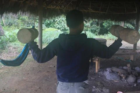 A hispanic person showing off his muscles, by holding two halters in the air Stock Photos