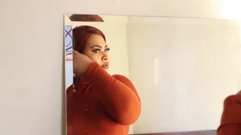 Hispanic plus size woman combing her hair in front of a mirror. mexican chubb Stock Footage 221360940