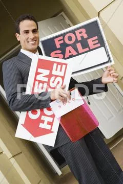 Hispanic real estate agent holding signs Stock Photos