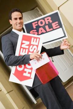 Hispanic real estate agent holding signs Stock Photos
