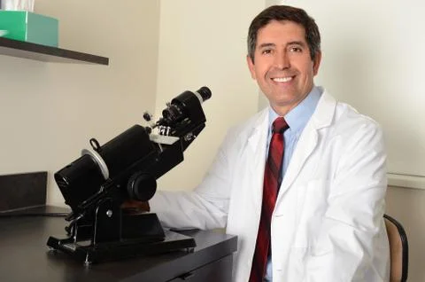 Hispanic researcher using microscope Stock Photos