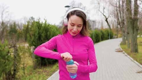A hispanic runner jogging on a sunny day, pausing Stock Footage 234693107