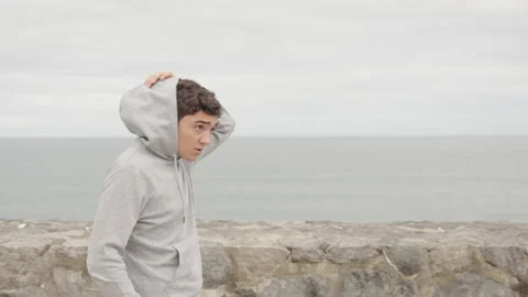 Hispanic runner stops jogging and takes off the hood Stock Footage 217371495