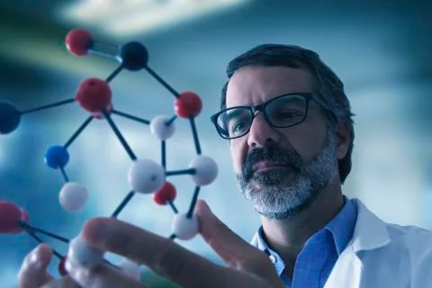Hispanic scientist examining molecule model Stock Photos