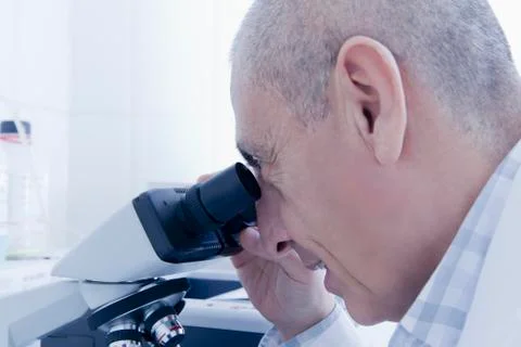 Hispanic scientist using microscope in lab 스톡 사진