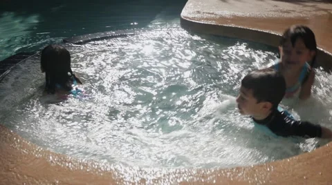 HISPANIC SIBLINGS PLAY IN A JACUZZI IN SLOW MOTION Stock Footage 54621964
