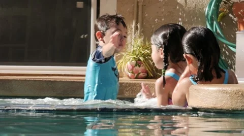 HISPANIC SIBLINGS SPLASH IN POOL IN SLOW MOTION Stock Footage 54621882