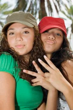 Hispanic teenaged girls making hand gestures Stock Photos