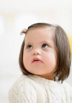 Hispanic toddler with Down syndrome looking up Stock Photos