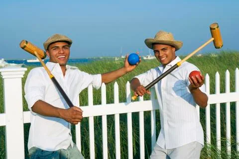 Hispanic twin brothers holding croquet mallets Stock Photos
