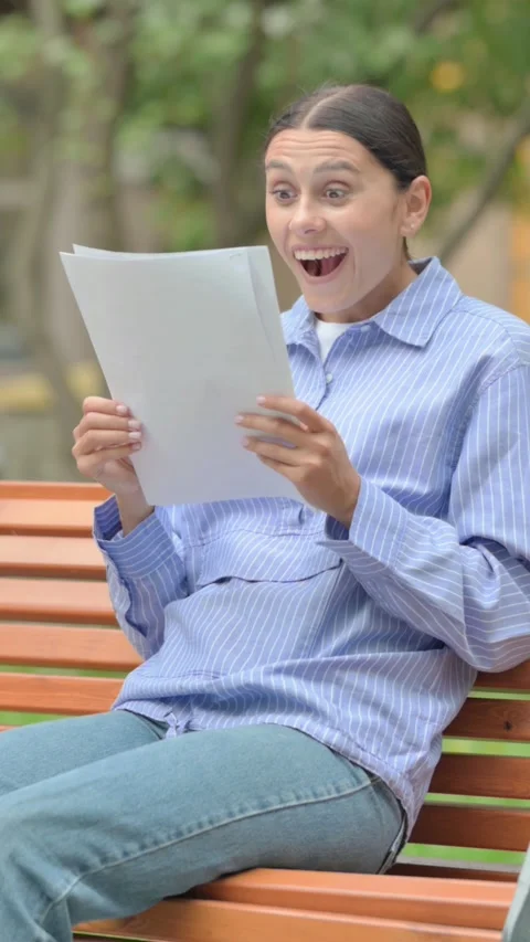 Hispanic Woman Celebrating while Reading Documents Outdoor, vertical Video stock 321121673