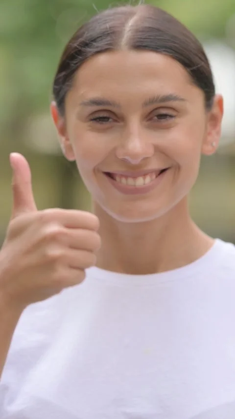 Hispanic Woman Doing Thumbs Up while Standing Outdoor, vertical Stock Footage 321121907