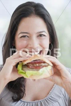 Hispanic Woman Eating Hamburger