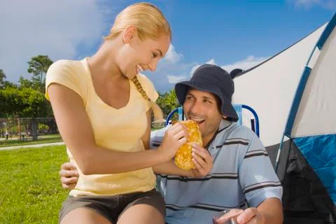 Hispanic woman feeding sandwich to boyfriend Stock Photos